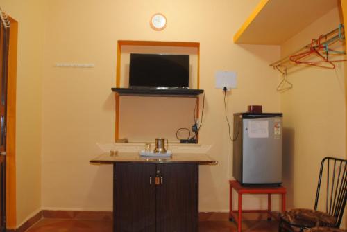 卡兰古特Joe And Marietta's Guesthouse的客房设有电视和小冰箱。