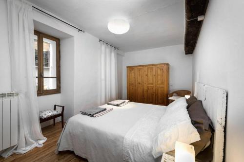 瓦拉洛Al vicolo del Gallo APPARTAMENTO的卧室配有白色的床和窗户。