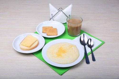 喀山那贝雷兹诺迷你酒店的一张桌子,上面放着两盘食物和一杯牛奶
