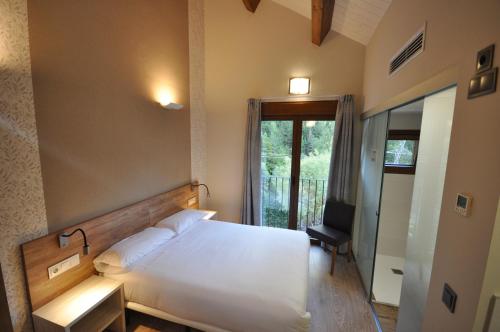 托尔拉露营谷布甲雷洛旅馆的一间卧室配有一张床、一张书桌和一个窗户。