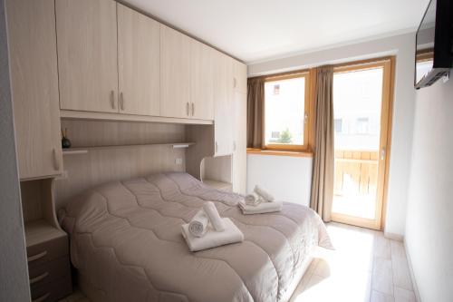 安达洛Perla delle Dolomiti的一间卧室配有带毛巾的床