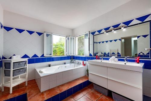 卡拉隆加梅赛德斯别墅的蓝色和白色的浴室设有浴缸和水槽
