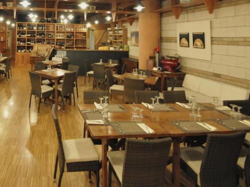 Poggio Picenze德拉奥斯特利亚波斯塔酒店的一间设有木桌和椅子的餐厅