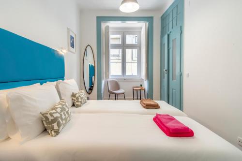 里斯本LV Premier Baixa DO的一间卧室配有一张白色大床,上面有红色毛巾