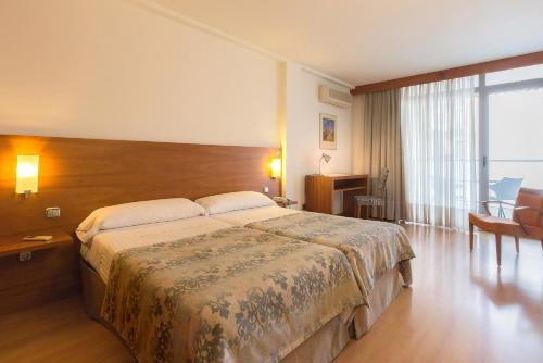 图德拉托雷蒙雷阿尔酒店的一间卧室设有一张大床和一个大窗户