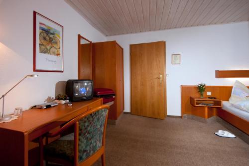 哥达Pension Cafe Suzette的酒店客房配有一张书桌、一台电视和一张床