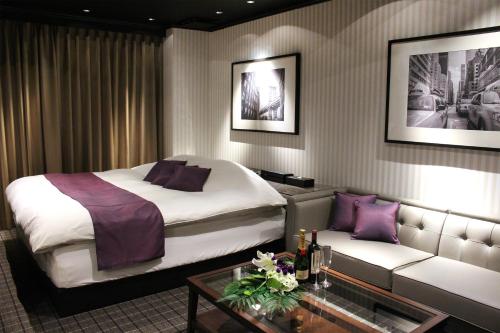 北九州Hotel LOVE MODERN的酒店客房,配有床和沙发