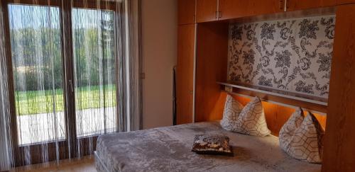 法克湖畔杜罗博拉赫帕尔克公寓的一间卧室设有一张床和一个大窗户