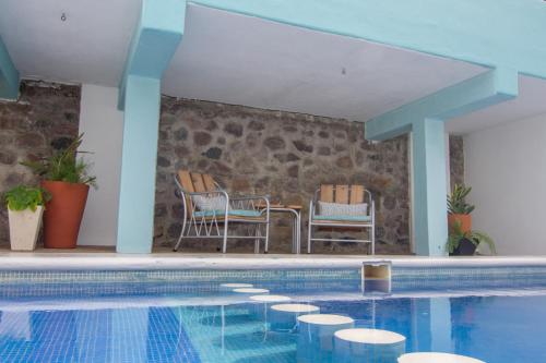 恰卡拉Hotel Pura Chacala的一个带两把椅子和一张桌子的游泳池