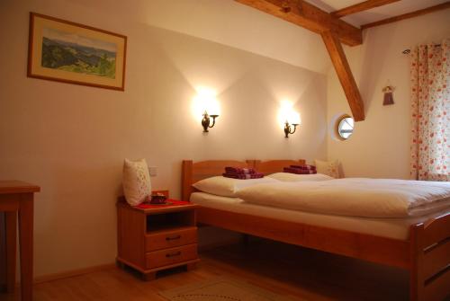 斯洛文尼亚格拉代茨罗特维尼克农场酒店的一间卧室配有两张床,墙上有两盏灯