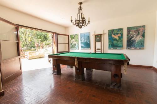Núcleo MauáHotel Casa Alpina的一间带台球桌和吊灯的客房