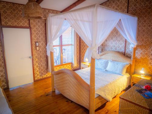 TufiTufi Resort的一间卧室设有天蓬床和窗户。