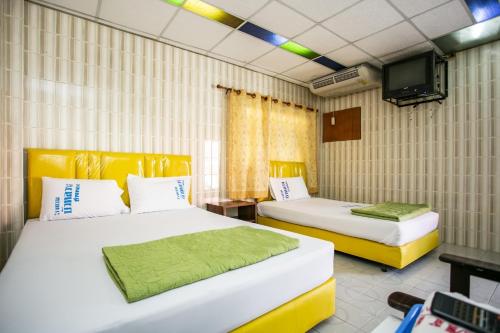 红统府布阿鲁昂酒店的一间设有两张床和电视的房间