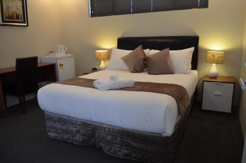 珀斯埃拉德住宿加早餐酒店的卧室配有一张带白色床单和枕头的大床。
