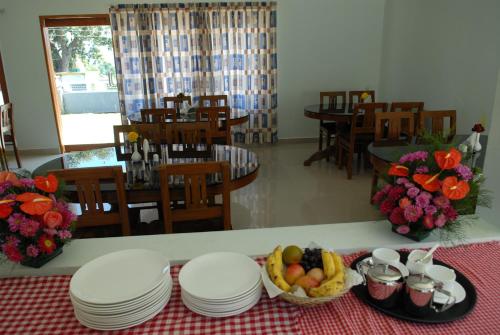 钦纳卡纳Holiday Heaven Munnar的一张桌子,上面放有盘子和一碗水果