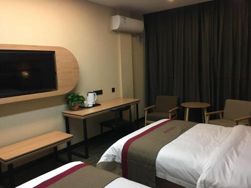 三门峡尚客优精选河南三门峡灵宝市长安路店的酒店客房设有两张床、一张桌子和一台电视。