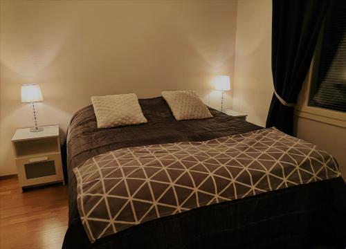 沃卡蒂Vuokatin Lumo的一间卧室配有一张大床和两盏灯