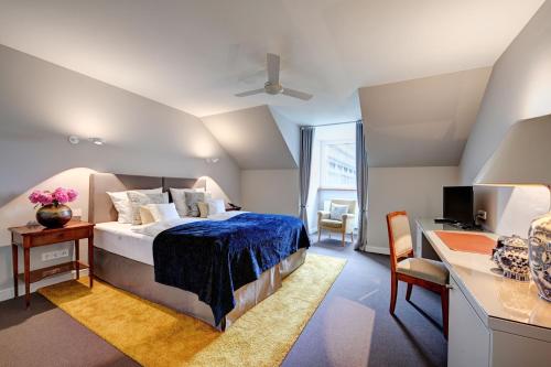 慕尼黑阿德米瑞酒店的一间卧室配有一张床和一张带电脑的书桌