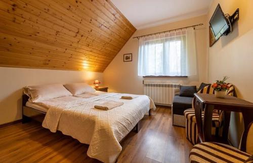 下乌斯奇基Noclegi u Kiesza的一间卧室配有一张大床和一张沙发