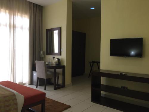 Ado EkitiAMOR Hotel Ekiti的酒店客房设有床、桌子和电视。