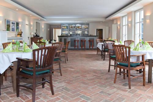绍尔夫海德Gut Sarnow - Hotel, Restaurant und Reitanlage的一间带桌椅的用餐室和一间厨房