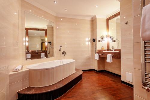 不来梅港阿马里斯酒店的带浴缸和盥洗盆的大浴室