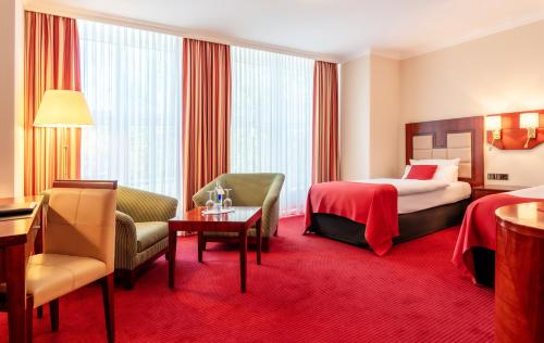 不来梅港阿马里斯酒店的酒店客房带一张床、一张桌子和椅子