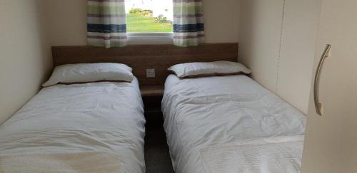 迪姆彻奇Gold Plus Caravan的小型客房 - 带2张床和窗户