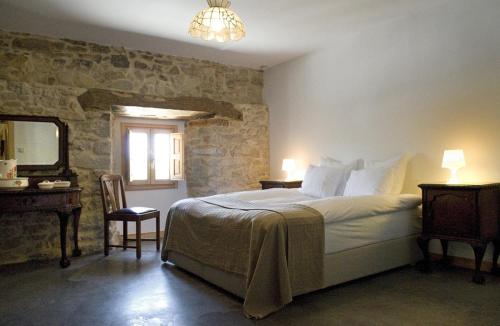 HedesoHotel Rural Casa La Sonrisa的一间卧室配有一张床、一张桌子和一面镜子