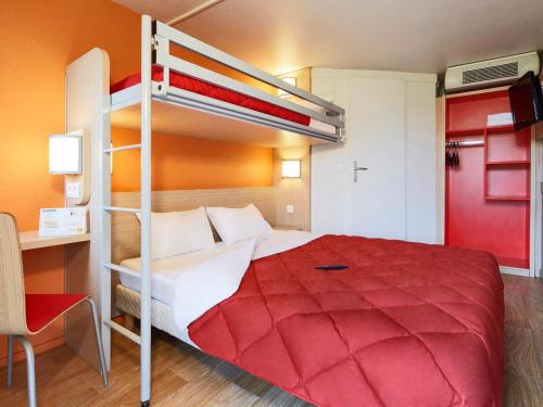 布拉尼亚克图卢兹西部布拉尼亚克机场高级酒店的一间卧室配有一张带红色床罩的双层床