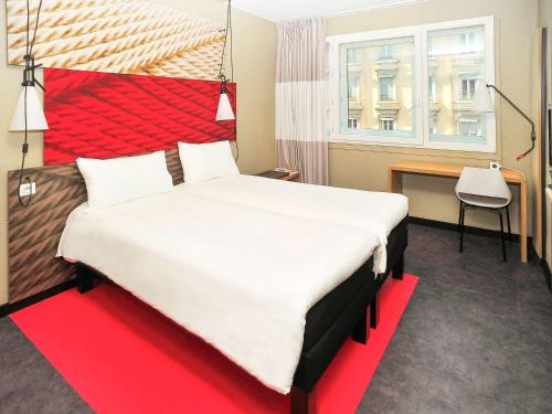 里昂里昂中心宜必思酒店的一间卧室配有一张大床和红色床头板