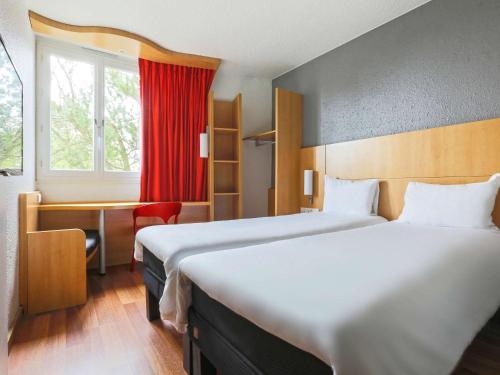 香槟沙隆宜恩沙隆香槟酒店的酒店客房设有两张床、一张书桌和一个窗户。