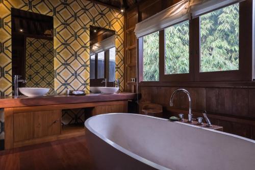 乌布Benisari Batik Garden Cottage的带浴缸和两个盥洗盆的大浴室