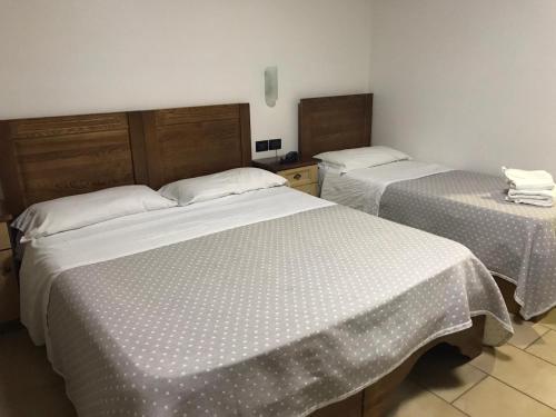 卡索里亚芙萝娅酒店的配有白色床单的酒店客房内的两张床