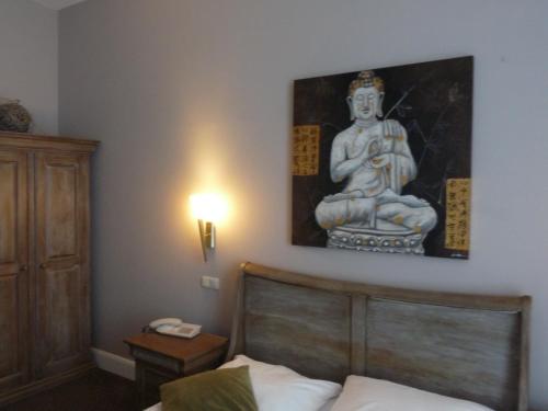 汉堡康莫德瑞酒店的卧室配有一张床铺,墙上挂着雕像