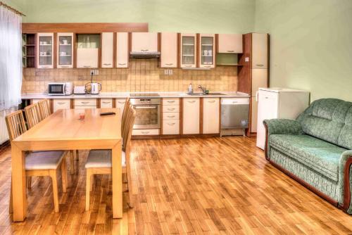 兹诺伊莫Apartmány pod Divadlem的厨房配有木桌和绿色沙发。
