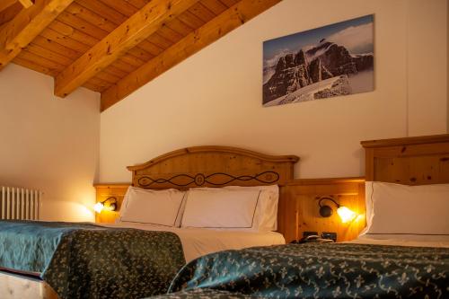 摩德纳迪-坎皮格里奥加尼拉索尔达内拉酒店的一间带两张床的卧室和山脉