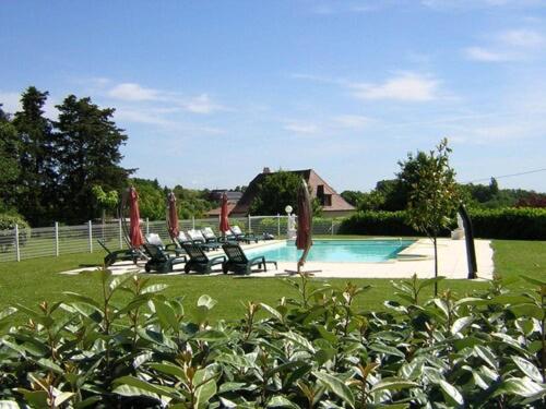 利梅伊Les BALCONS de L'ESPERANCE的一个带躺椅的游泳池以及一座房子