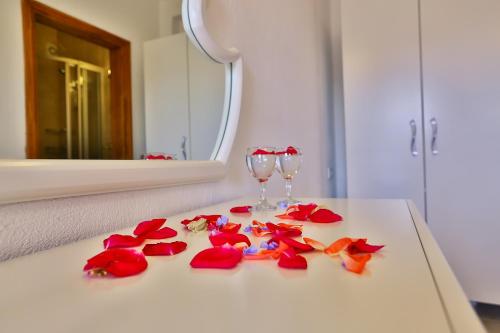 Kaleucagız奇科瓦戴姆萨旅馆的一张白色桌子,上面有红花和玻璃杯