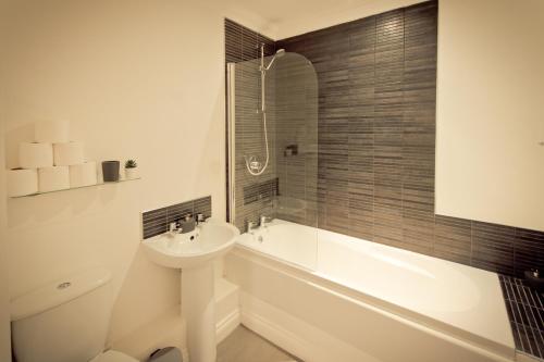 普里茅斯Top View 2 Bedroom Apartments Plymouth的一间带水槽、浴缸和卫生间的浴室