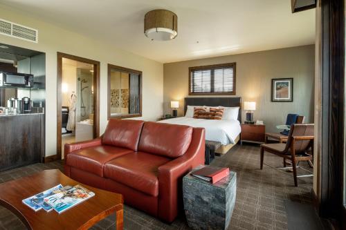 本德Tetherow Hotel的酒店客房配有一张床和一张皮沙发