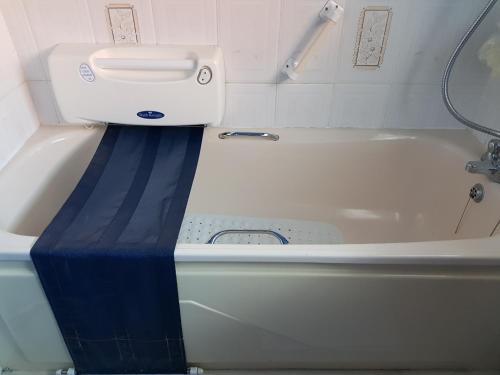 贝尔法斯特CEAD MILE FAILTE WEST BELFAST的浴室内设有一个蓝色条纹的白色浴缸