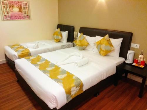 吉隆坡Hotel Sunjoy9 @ Mid Valley的两张位于酒店客房的床,配有毛巾