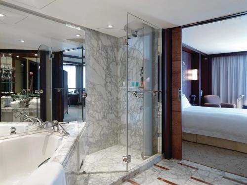 上海上海金茂君悦大酒店的一间带浴缸和淋浴的浴室以及一张床