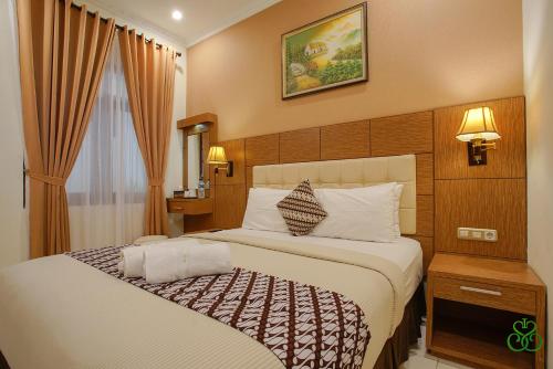 日惹Selaras Inn Syariah的一间位于酒店客房内的带大床的卧室