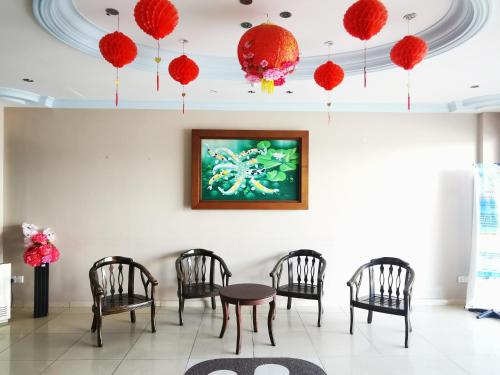 瓜埠桑德兰汽车旅馆的一间设有椅子和一张桌子的房间,墙上有一幅画
