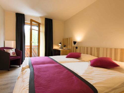 EggolsheimBrauerei_Gasthof Pfister的卧室配有一张带红色和粉红色枕头的大床