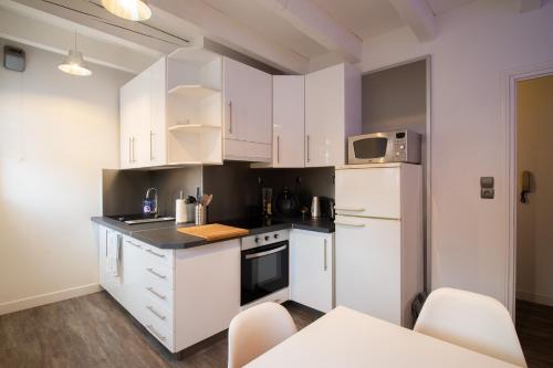 科尔马Le rohan sawadee的厨房配有白色橱柜和白色冰箱。