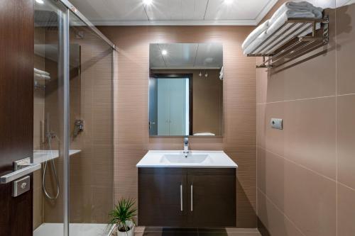 卡拉德米哈斯Apartment front Line La Cala Golf Resort的一间带水槽、镜子和淋浴的浴室