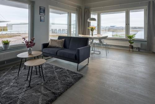 阿兰达Forenom Hotel Arlanda的客厅配有沙发、桌子和窗户